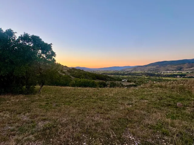 Expansive open land with a backdrop of distant hills and valley terrain