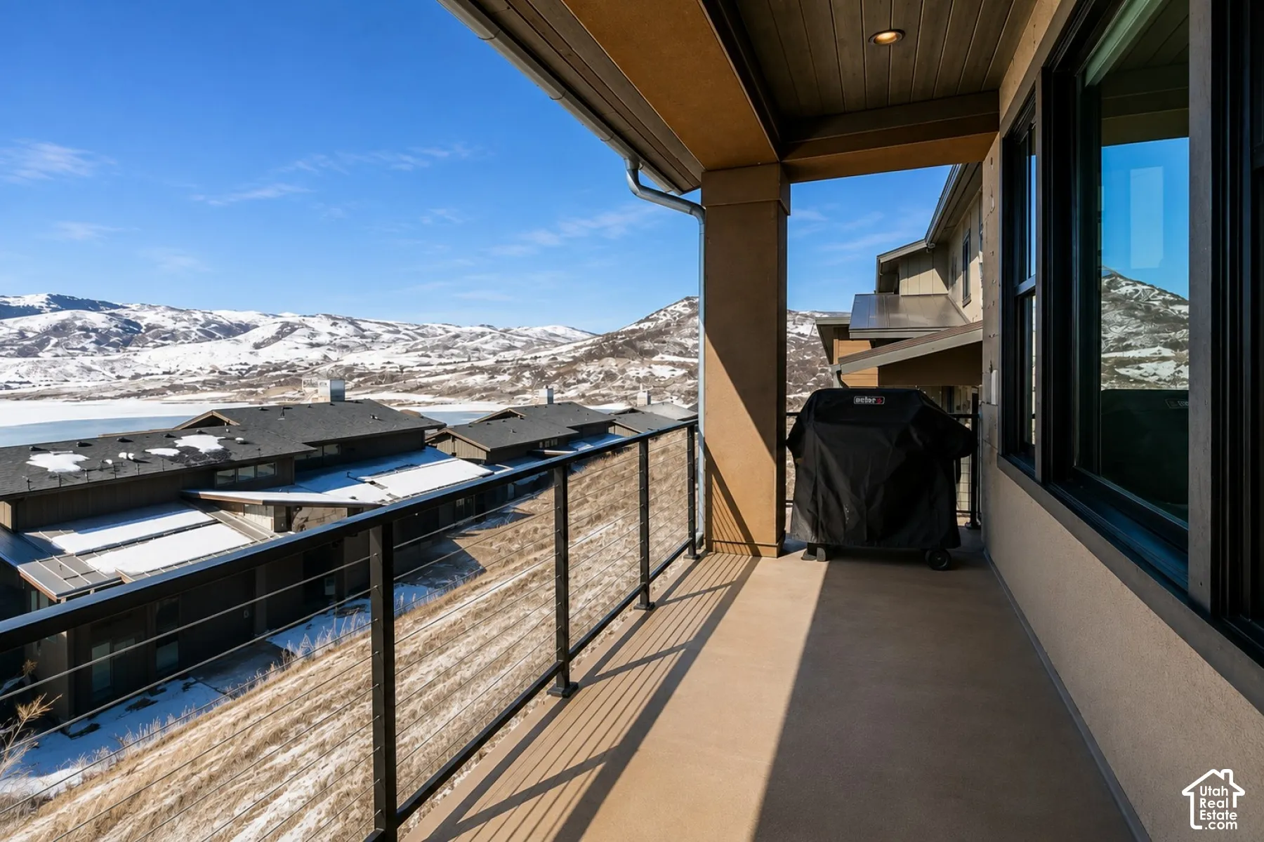 Covered balcony with a concrete floor, recessed lighting, and a glass panel railing