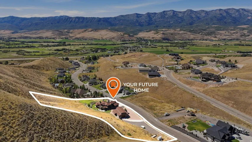 Expansive undeveloped lot with a mountainous backdrop, positioned on a paved road within a residential setting