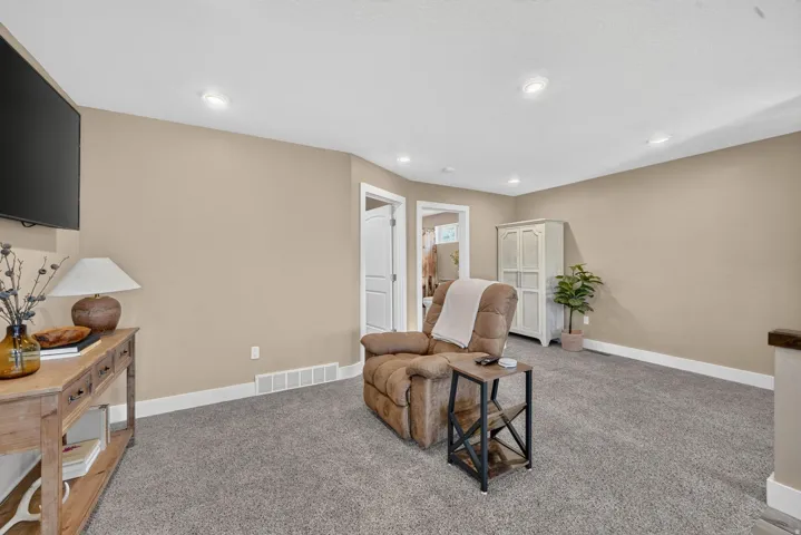 Neutral wall color, recessed lighting, carpet flooring, white trim, and a white interior door