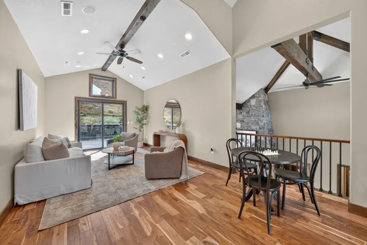 Vaulted ceilings featuring exposed wood beams, recessed lighting, and a ceiling fan