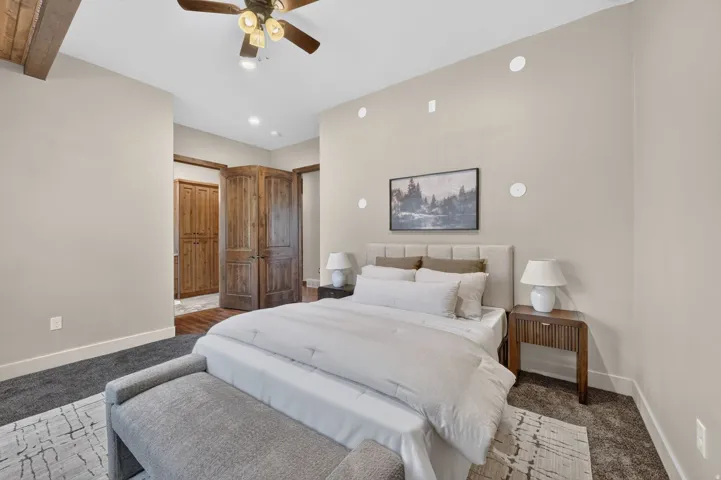 Textured carpet flooring, recessed ceiling lighting, wood-finish ceiling fan, wood-finish doors, and wood-finish trim