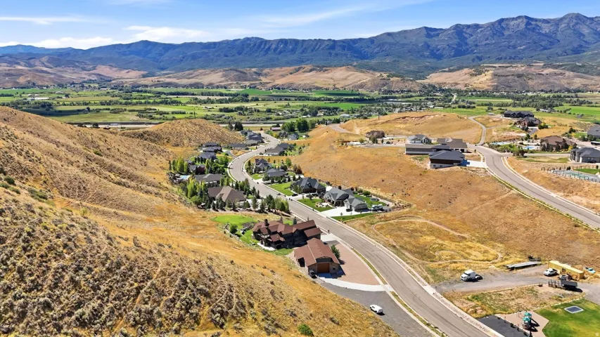 Mountainous terrain with expansive undeveloped land, established residential streets, and distant valley