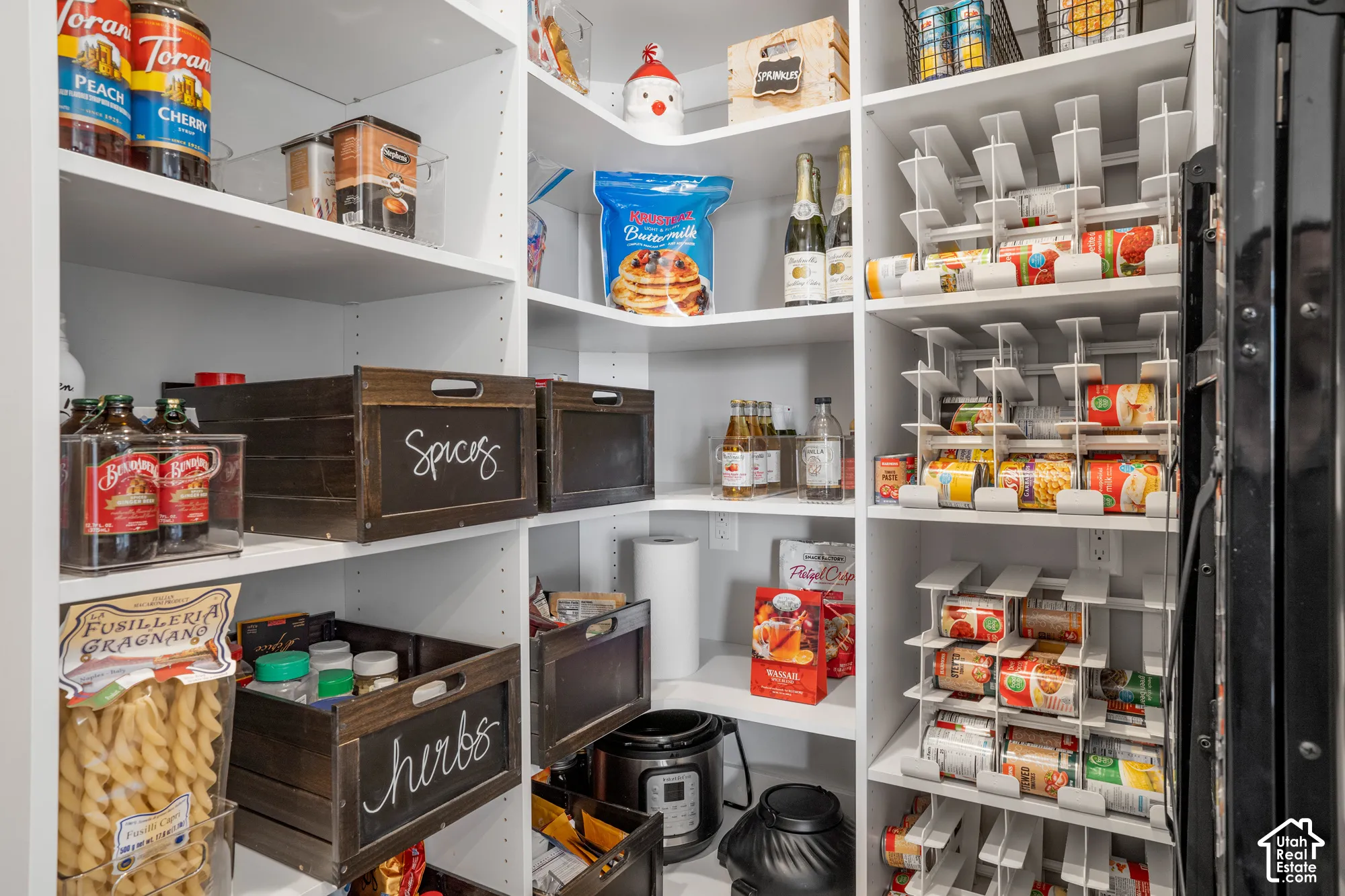 Built-in shelving with adjustable white shelves, integrated can organizers, and dedicated appliance storage