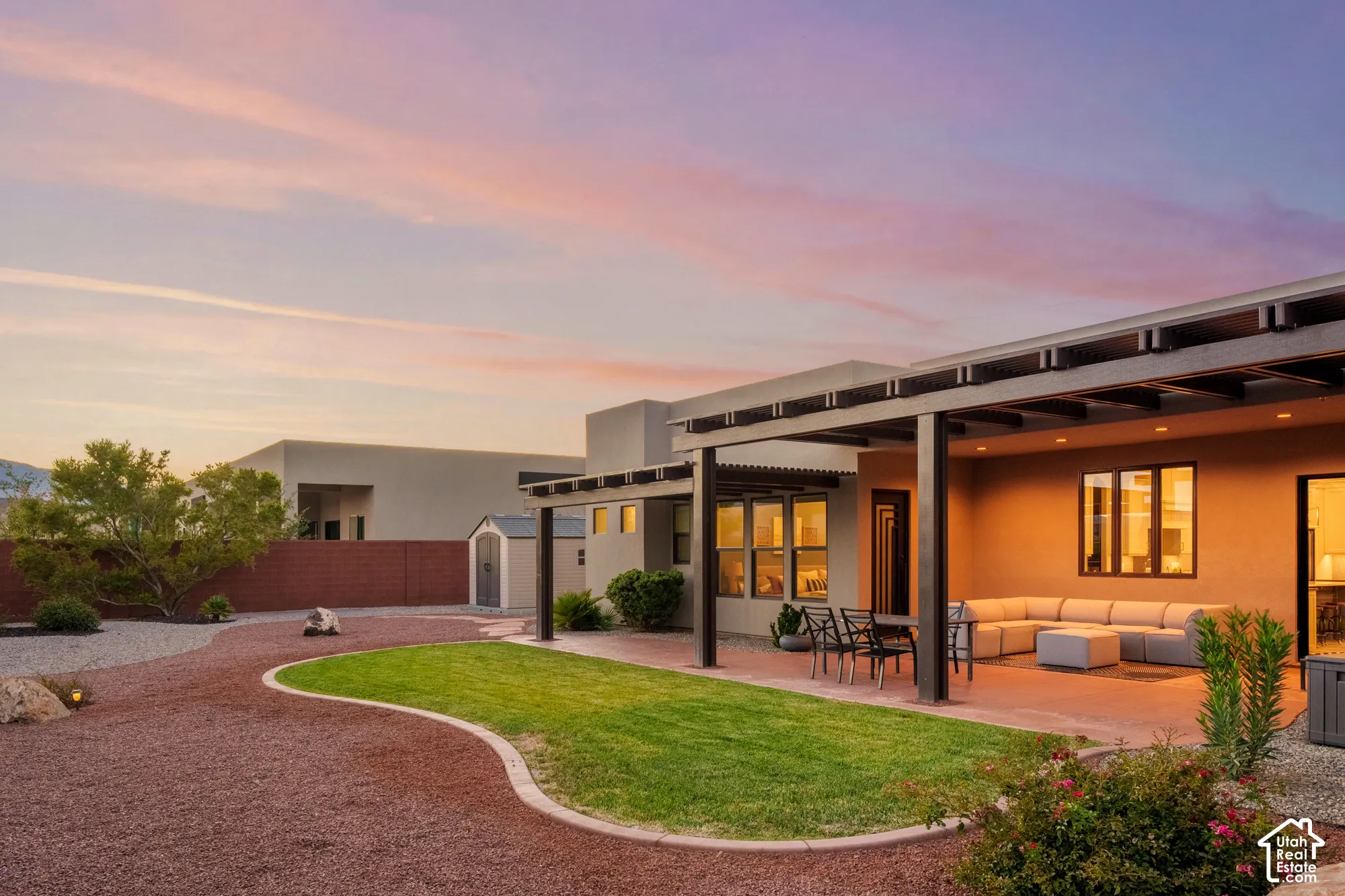 Expansive backyard featuring a covered patio, pergola, manicured lawn, and decorative gravel