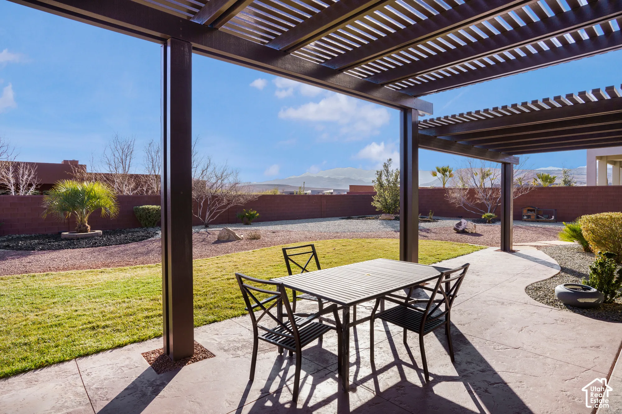 Expansive covered patio with stamped concrete, offering shade and outdoor dining space