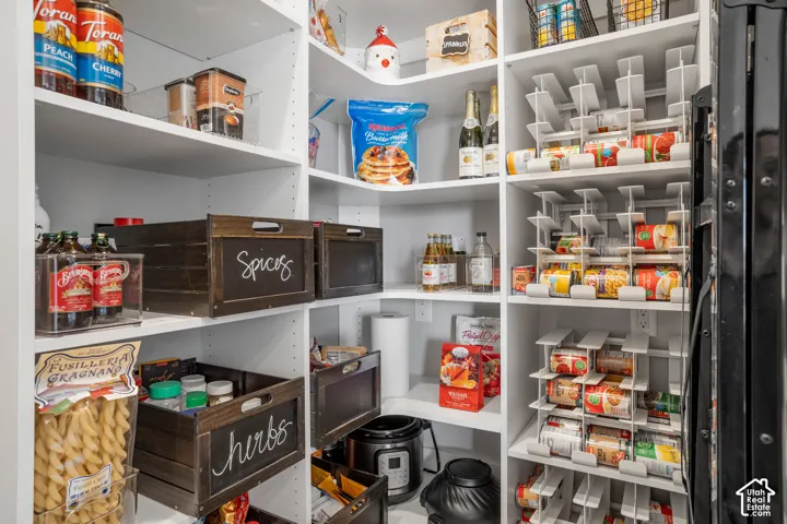 Built-in shelving with adjustable white shelves, integrated can organizers, and dedicated appliance storage