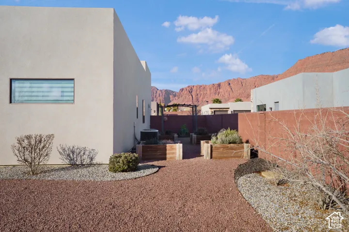 Stucco exterior with horizontal window, gravel landscaping, and raised garden beds