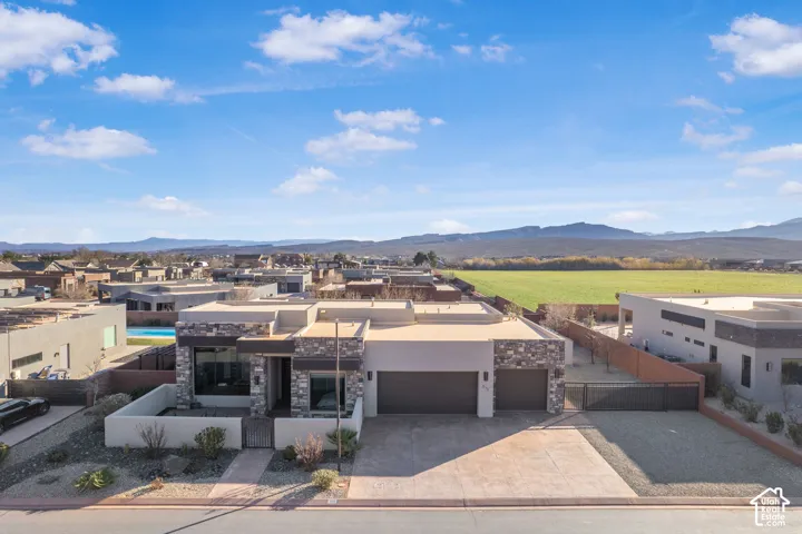 Contemporary residence featuring a flat roofline, stone and stucco exterior, two-car garage, and a gated side access