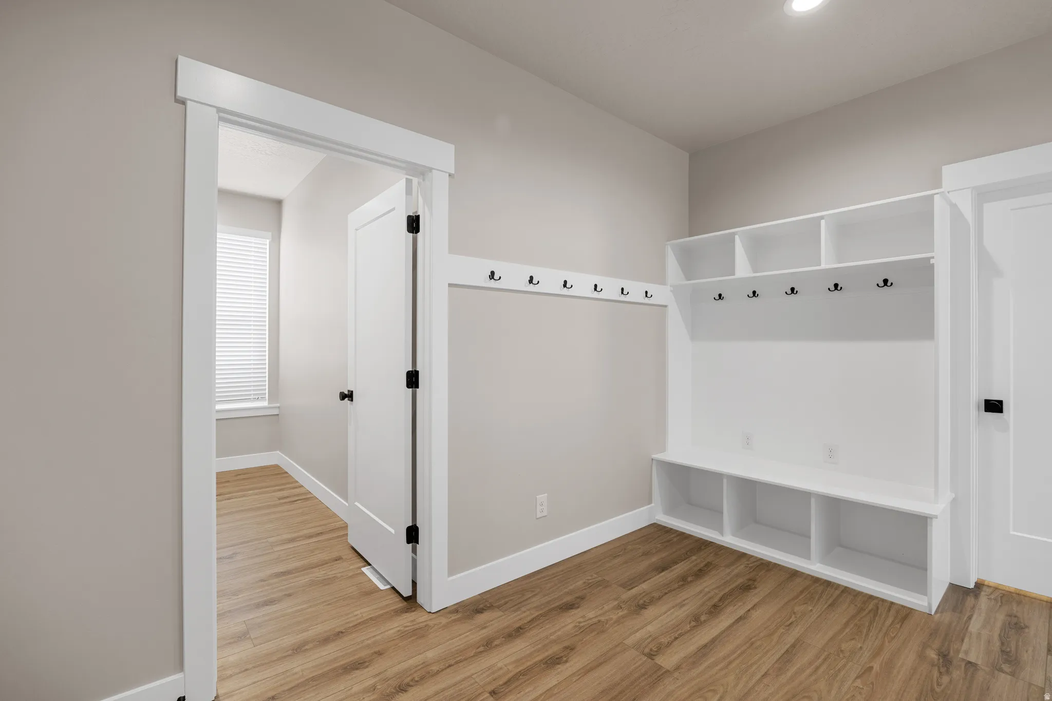 Built-in mudroom storage with integrated shelving, bench seating, and coat hooks