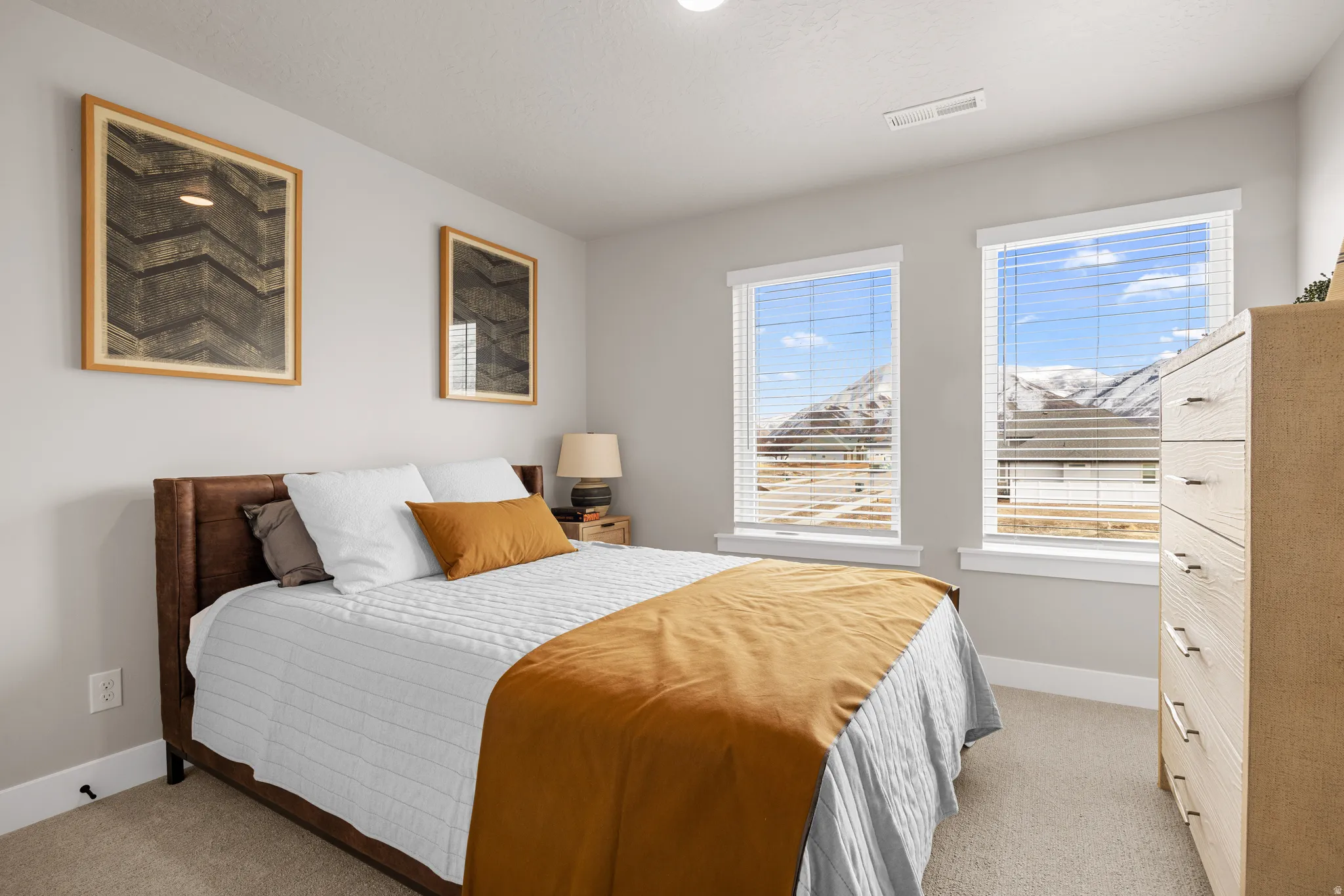 Carpeted flooring, two large windows with blinds, and white trim
