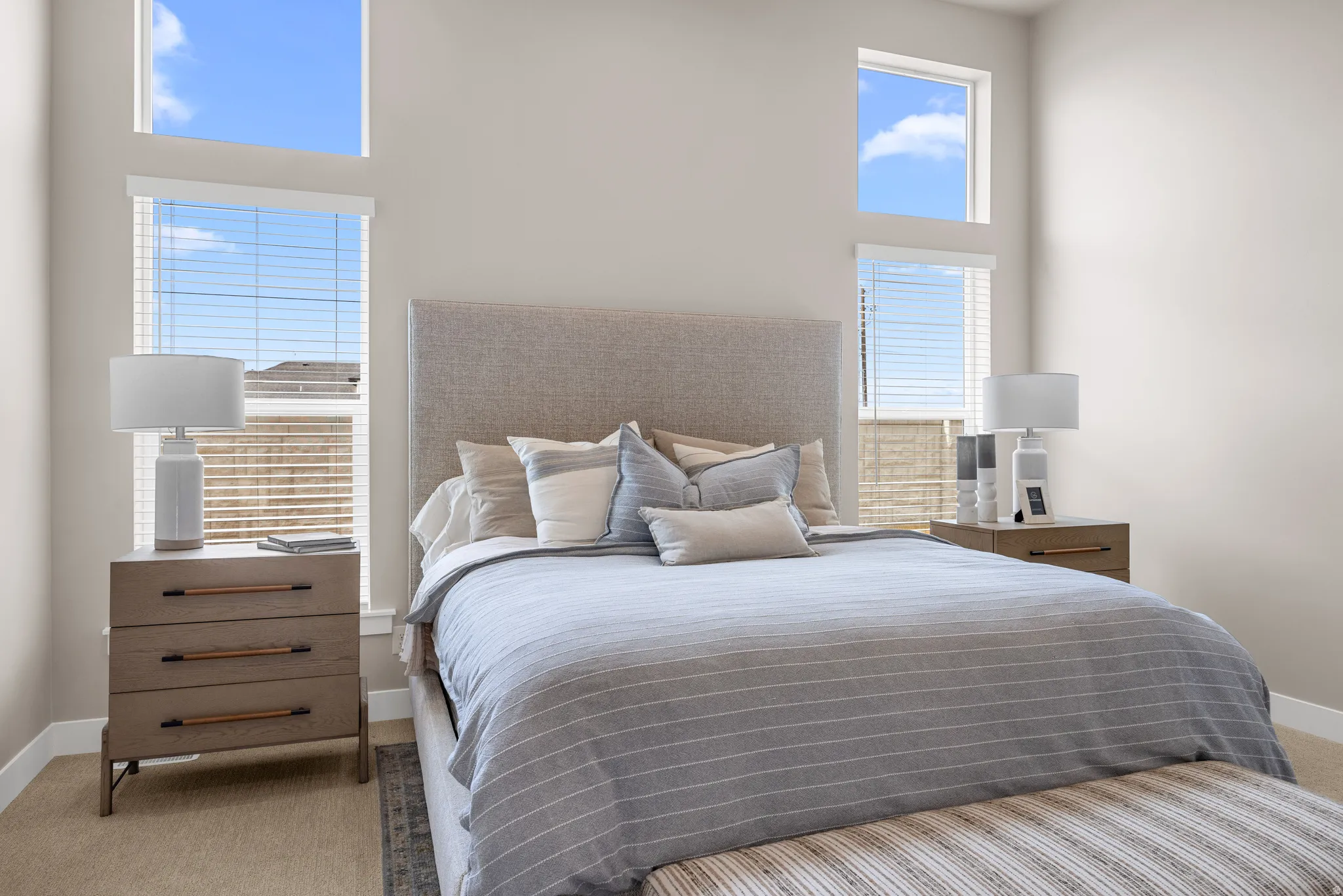 High ceilings with transom windows, white wall finishes, and light-colored carpet flooring