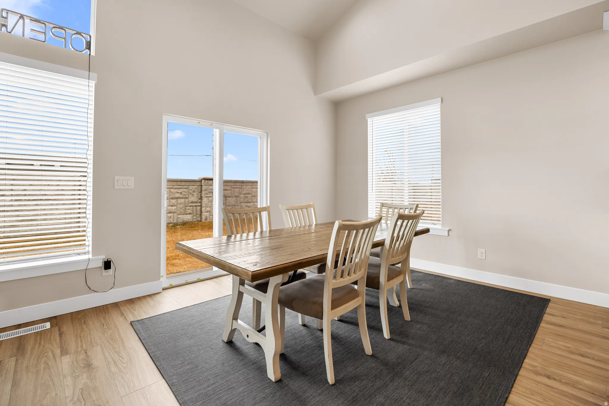 Vaulted ceiling, wood-finish flooring, sliding glass door, multiple windows, neutral wall tones
