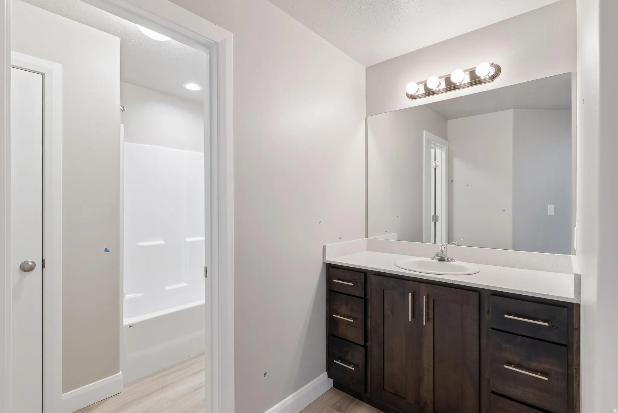 Dark wood-finish vanity with a white countertop and an integrated sink
