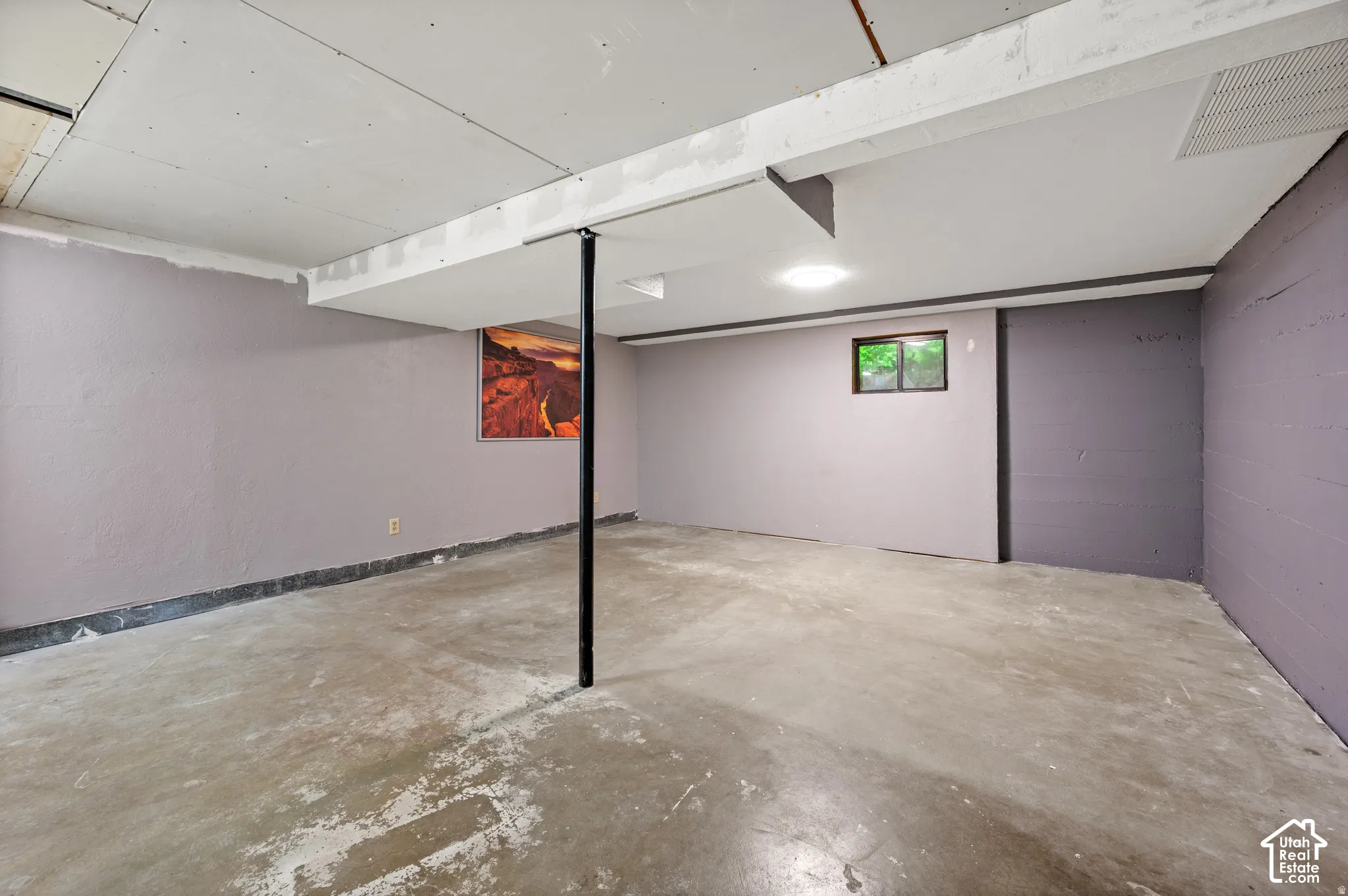 Finished concrete flooring with exposed ceiling beams and recessed lighting