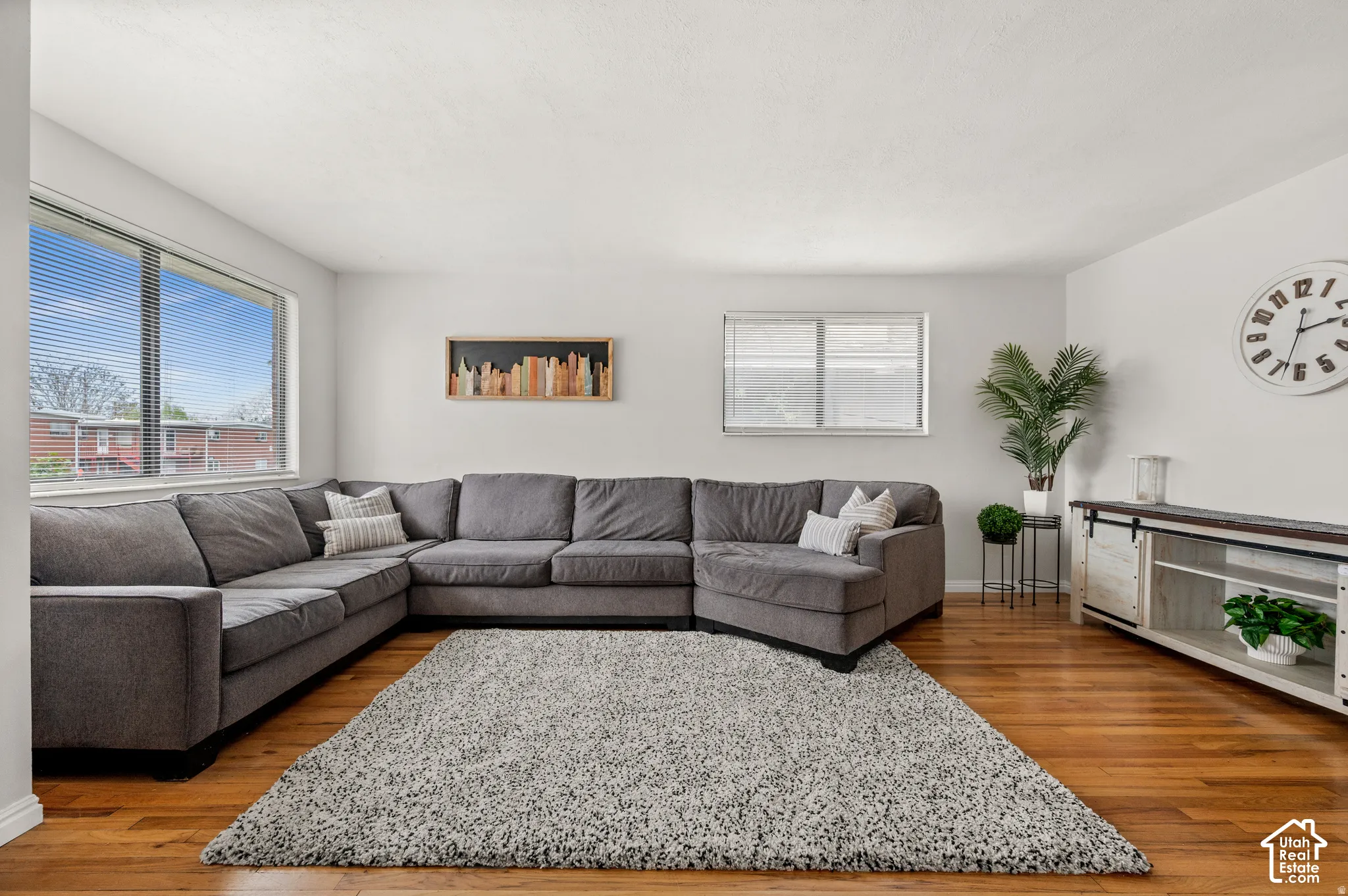 Hardwood flooring, white walls, and multiple windows