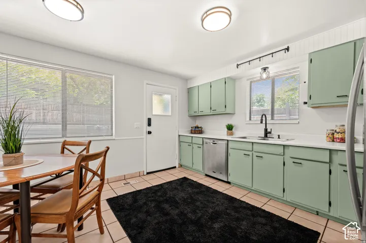 Kitchen featuring mint green cabinetry, white countertops, tile flooring, and a stainless steel dishwasher