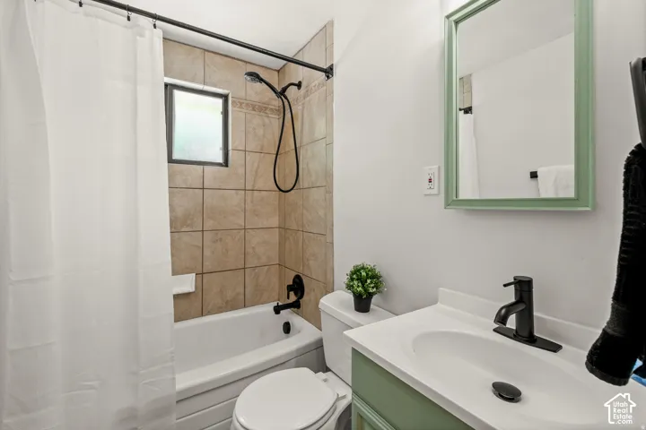 Built-in bathtub with a tile surround, black-finish shower fixtures, and a window