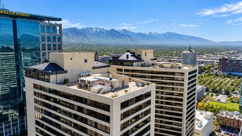 Rooftop terrace featuring a built-in spa, paved surfaces, and surrounding city and mountain scenery