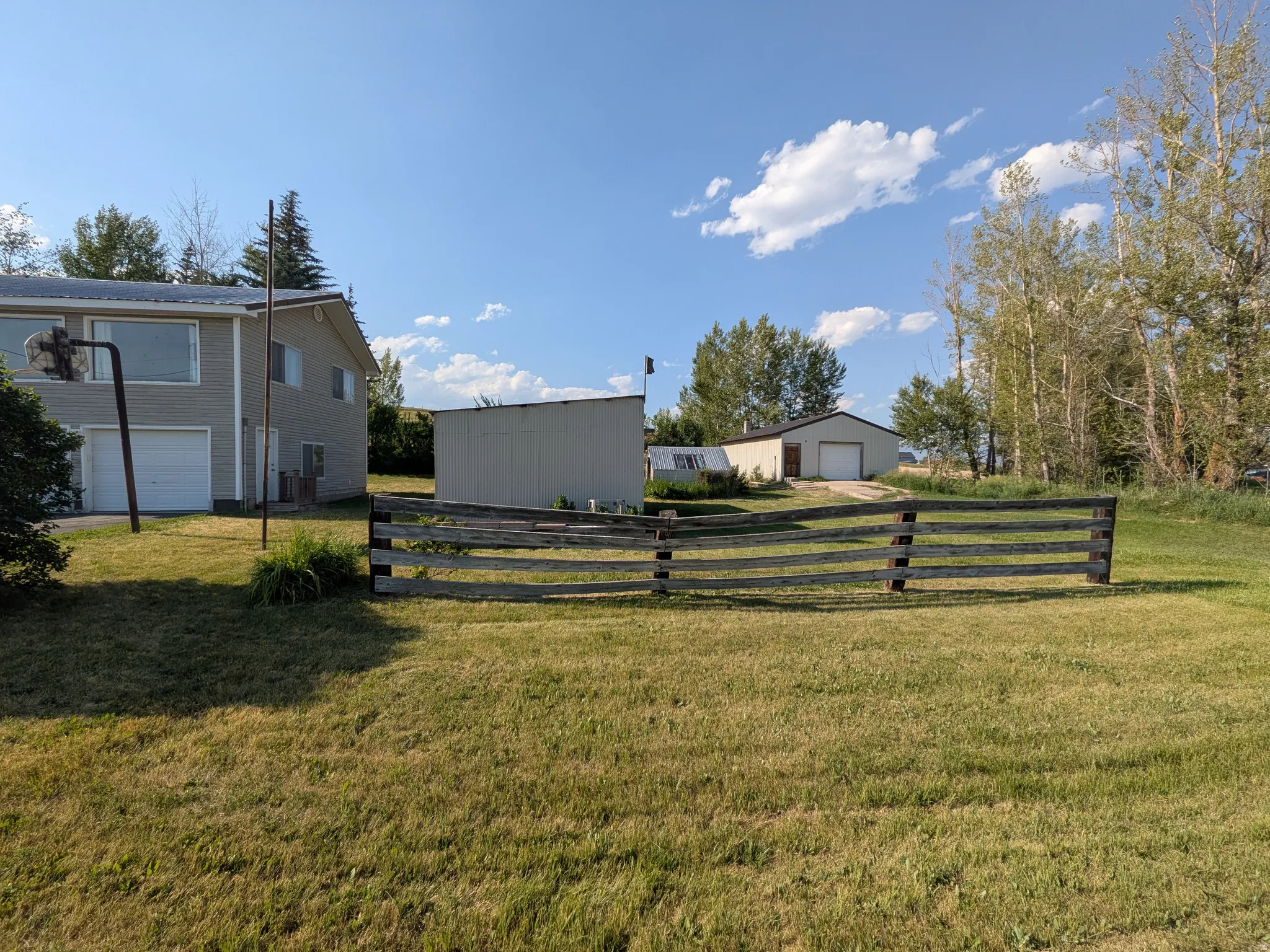 Two-story residential structure with dual garage doors and a detached auxiliary building