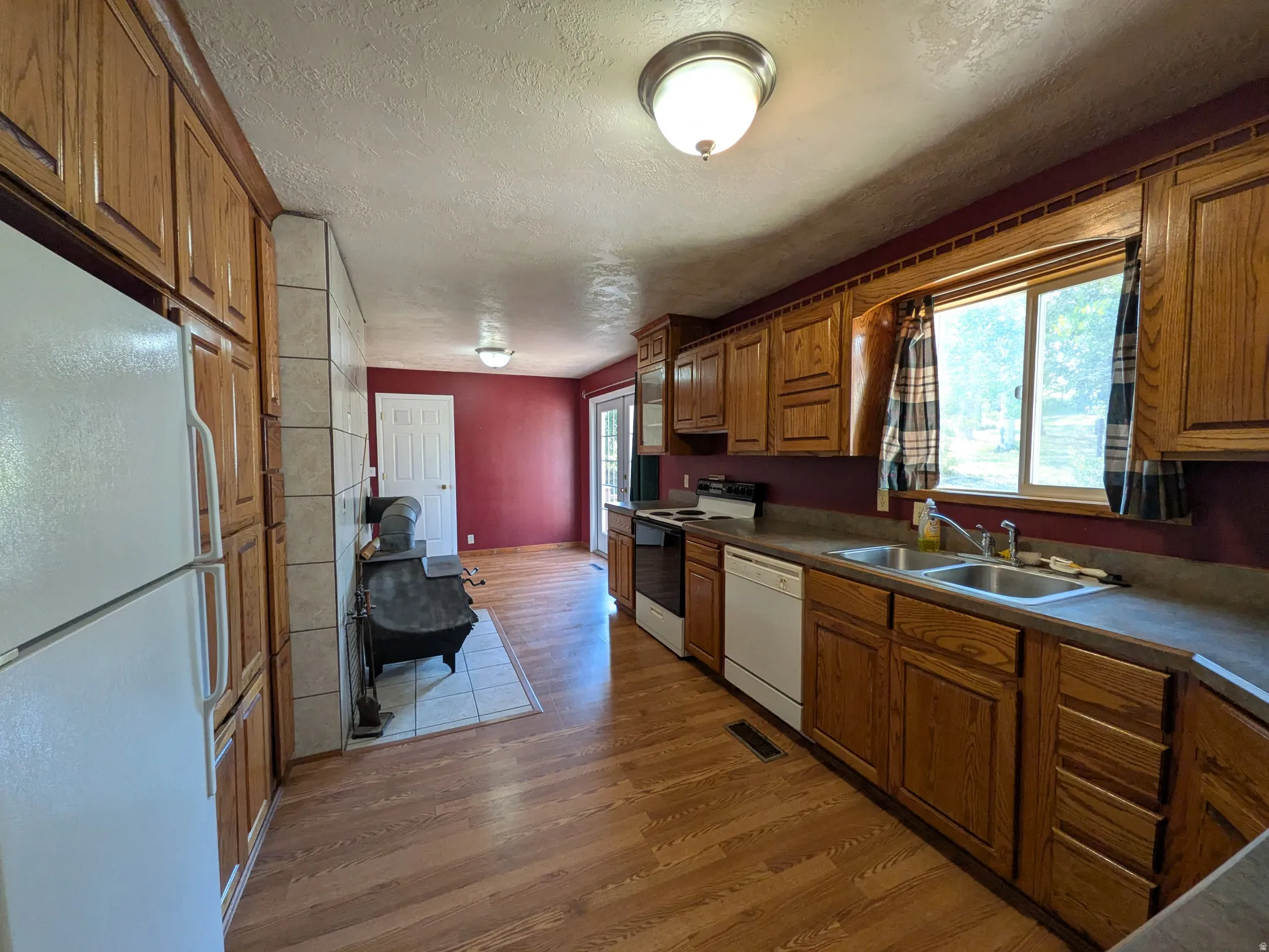 Wood-finish flooring throughout, complemented by wood cabinetry and built-in appliances