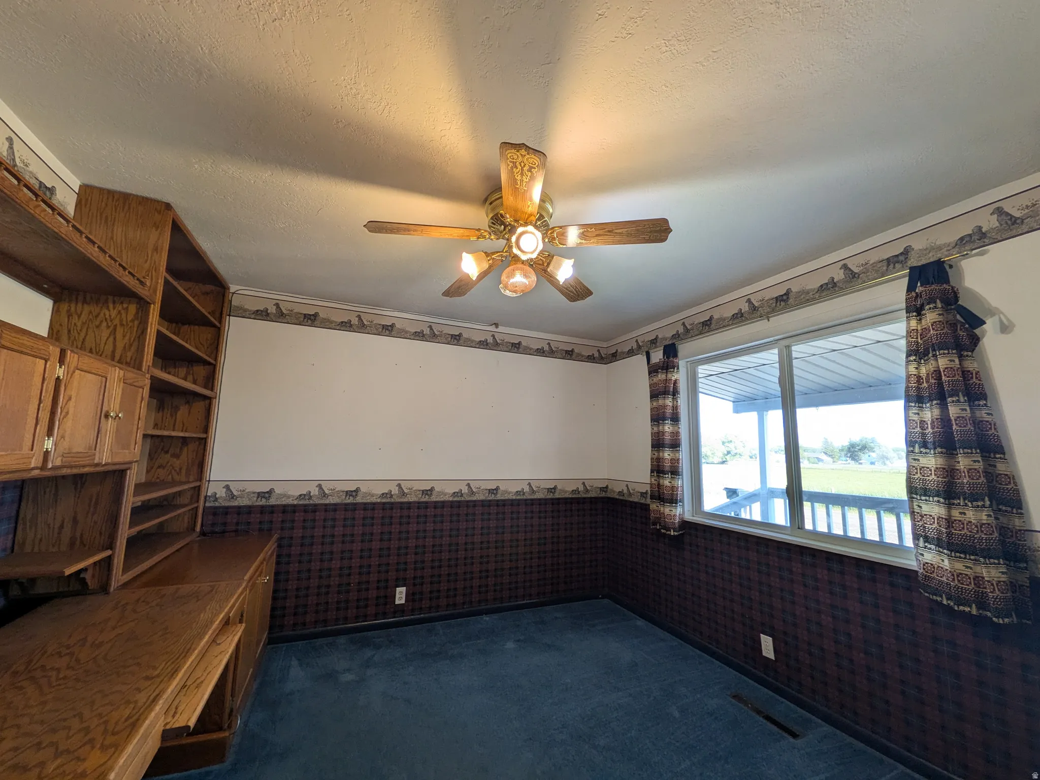 Built-in wood-finish cabinetry, built-in wood-finish shelving, overhead ceiling fan, and window