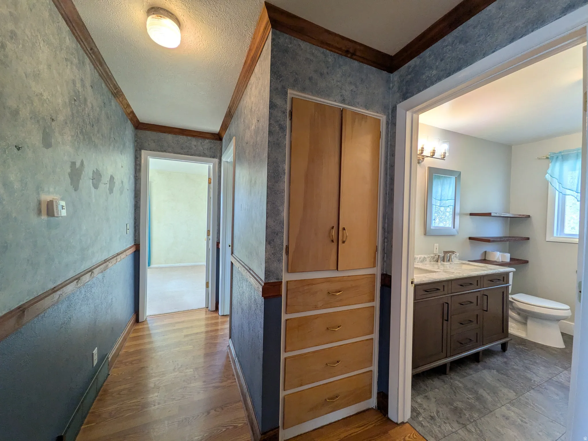 Hallway with wood-finish flooring and built-in storage cabinetry