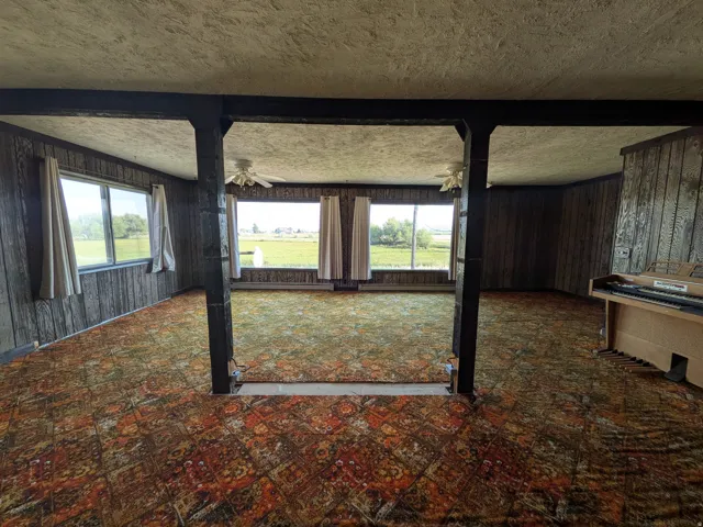 Wood-paneled walls and exposed structural beams with beautiful country views.