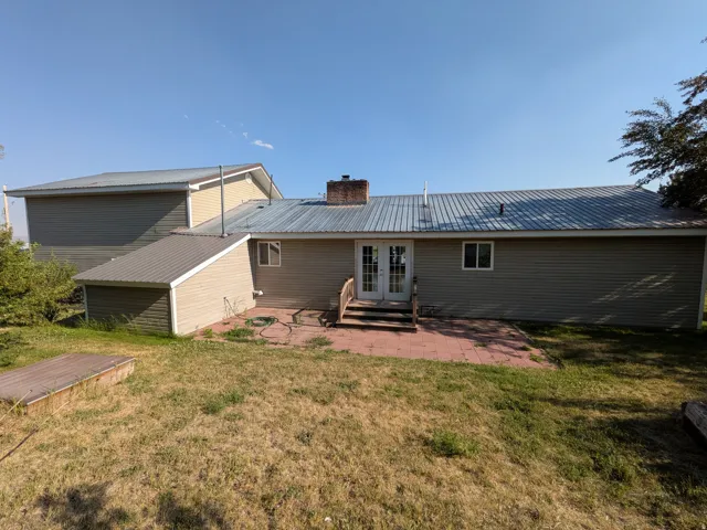 Light-colored siding exterior with a corrugated metal roof