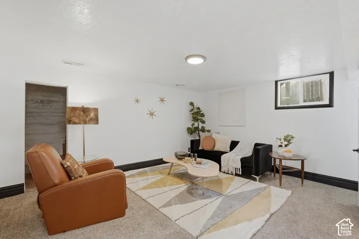 Downstairs Living Room: White walls with dark trim, recessed ceiling light, and a window with black trim