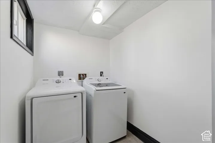 Compact laundry area with white walls and a single window