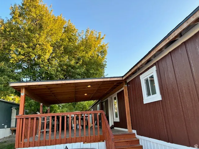 Covered porch with recessed lighting, wood-finish decking, and wood railings