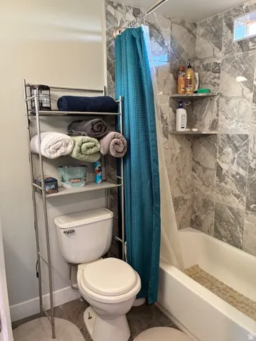 White bathtub with integrated shelving and a built-in window