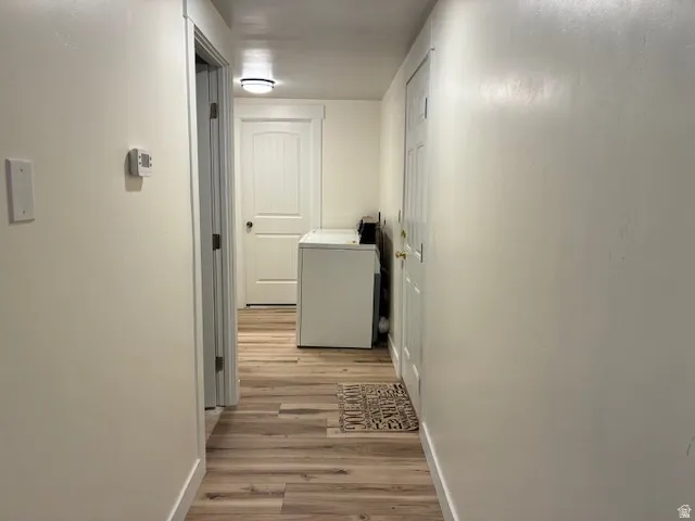 Hallway featuring wood-finish flooring and light-colored walls