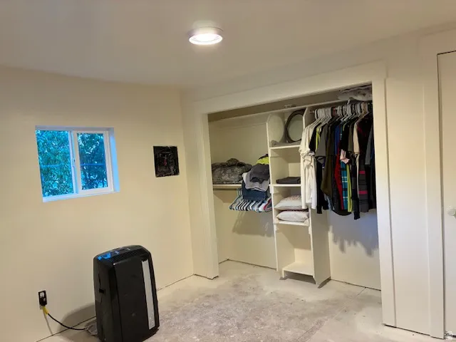 Spacious walk-in closet featuring built-in shelving, hanging rods, and ample storage capacity