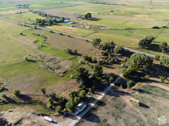 Expansive rural landscape featuring green fields, mature trees, Sanpitch River