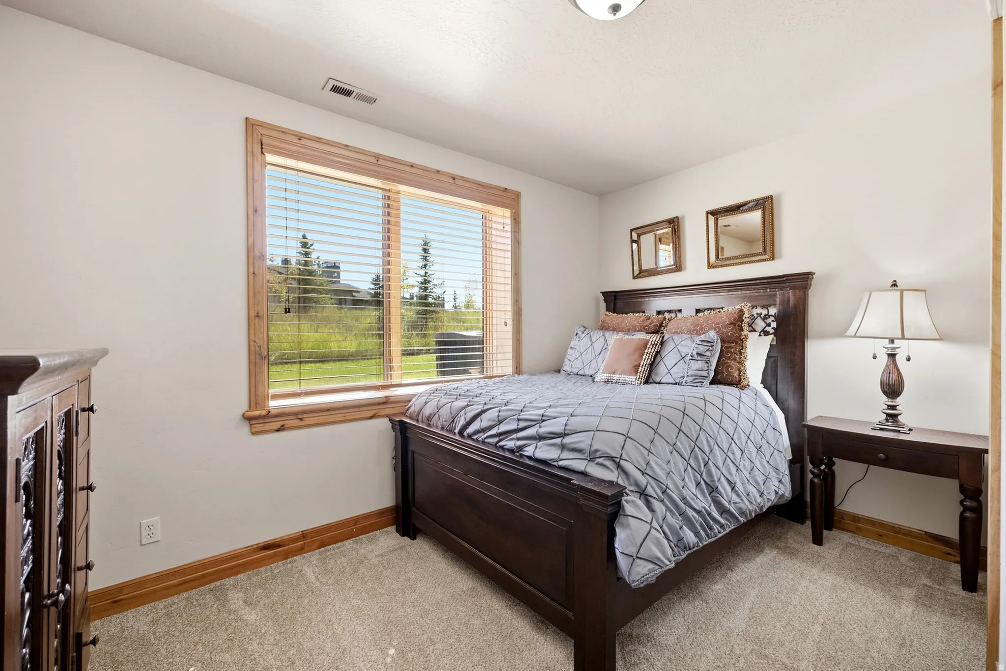Expansive window with wood trim, neutral wall color, and carpeted flooring