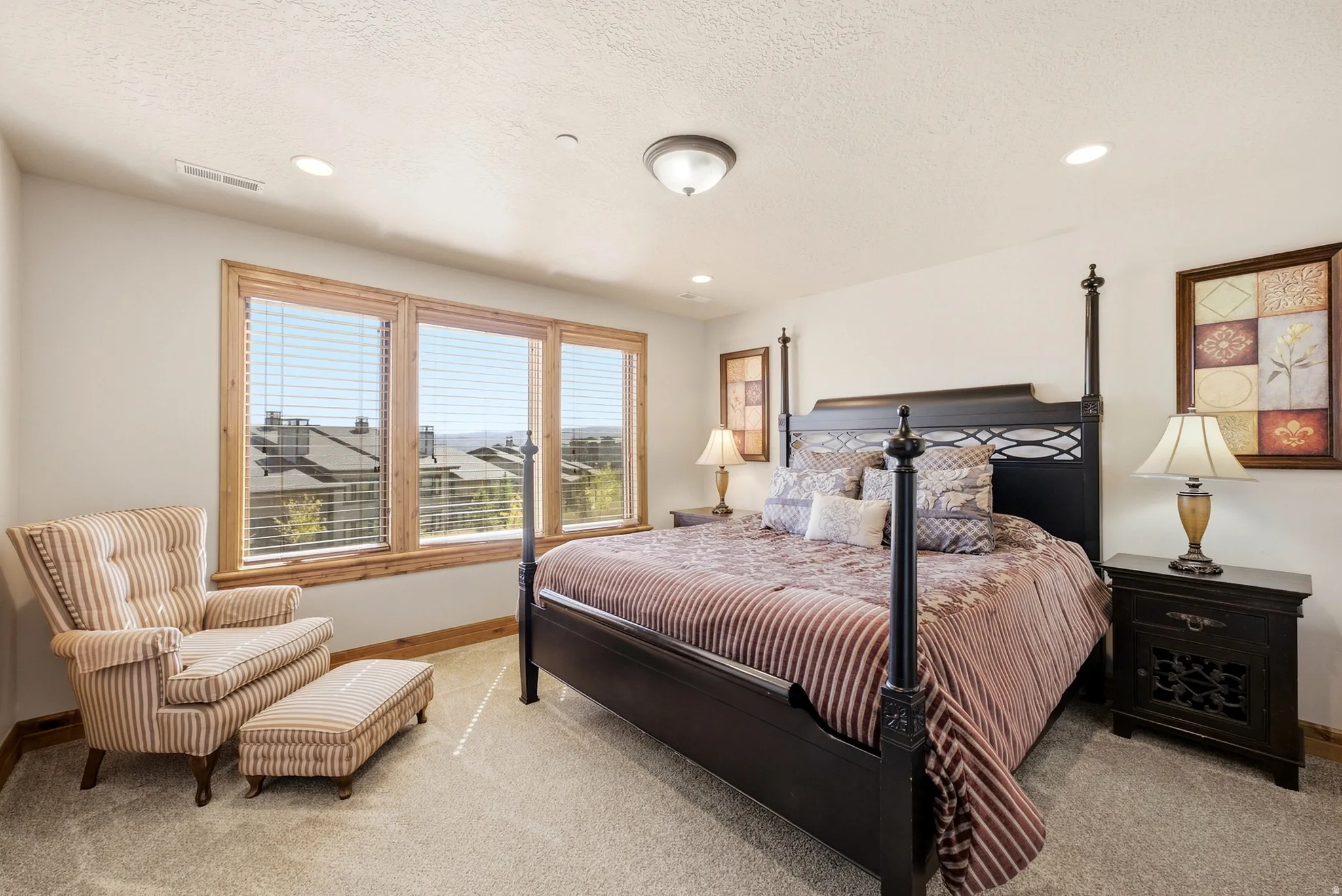Recessed lighting, wood-trimmed windows, neutral wall tones, textured ceiling, and carpeted flooring