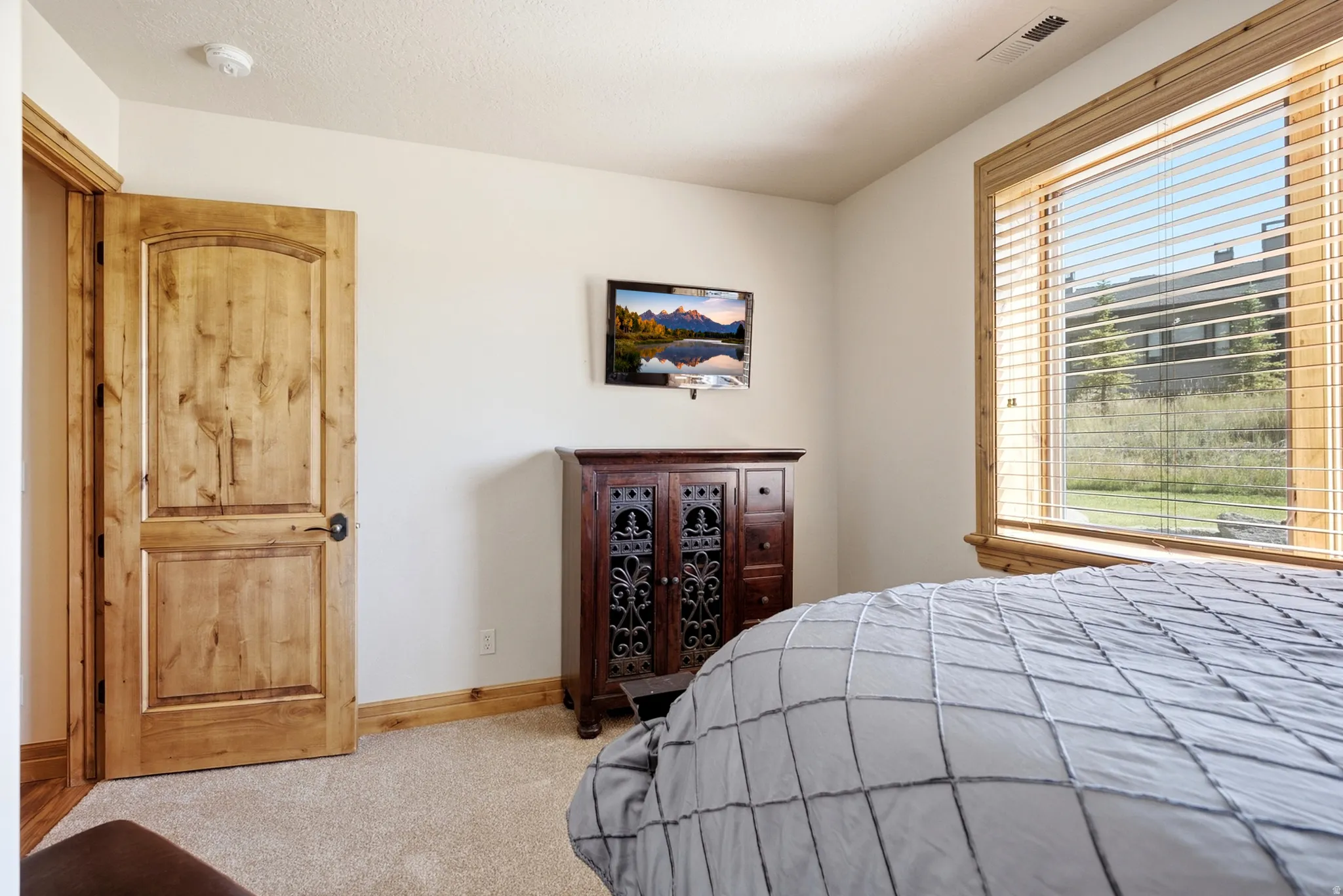 Neutral paint palette, wood-finish interior door, wood-finish window trim, and wall-to-wall carpeting