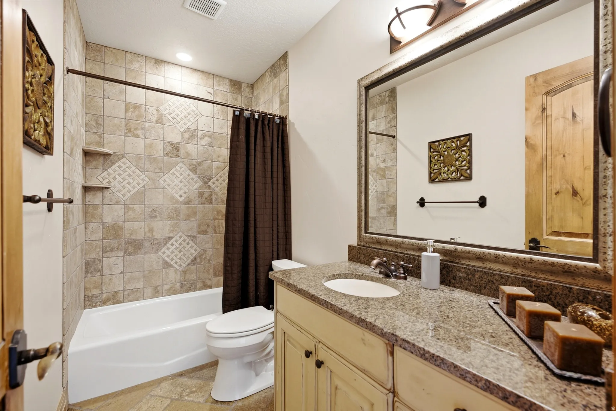 Stone-look tile shower surround with decorative accents and built-in shelving