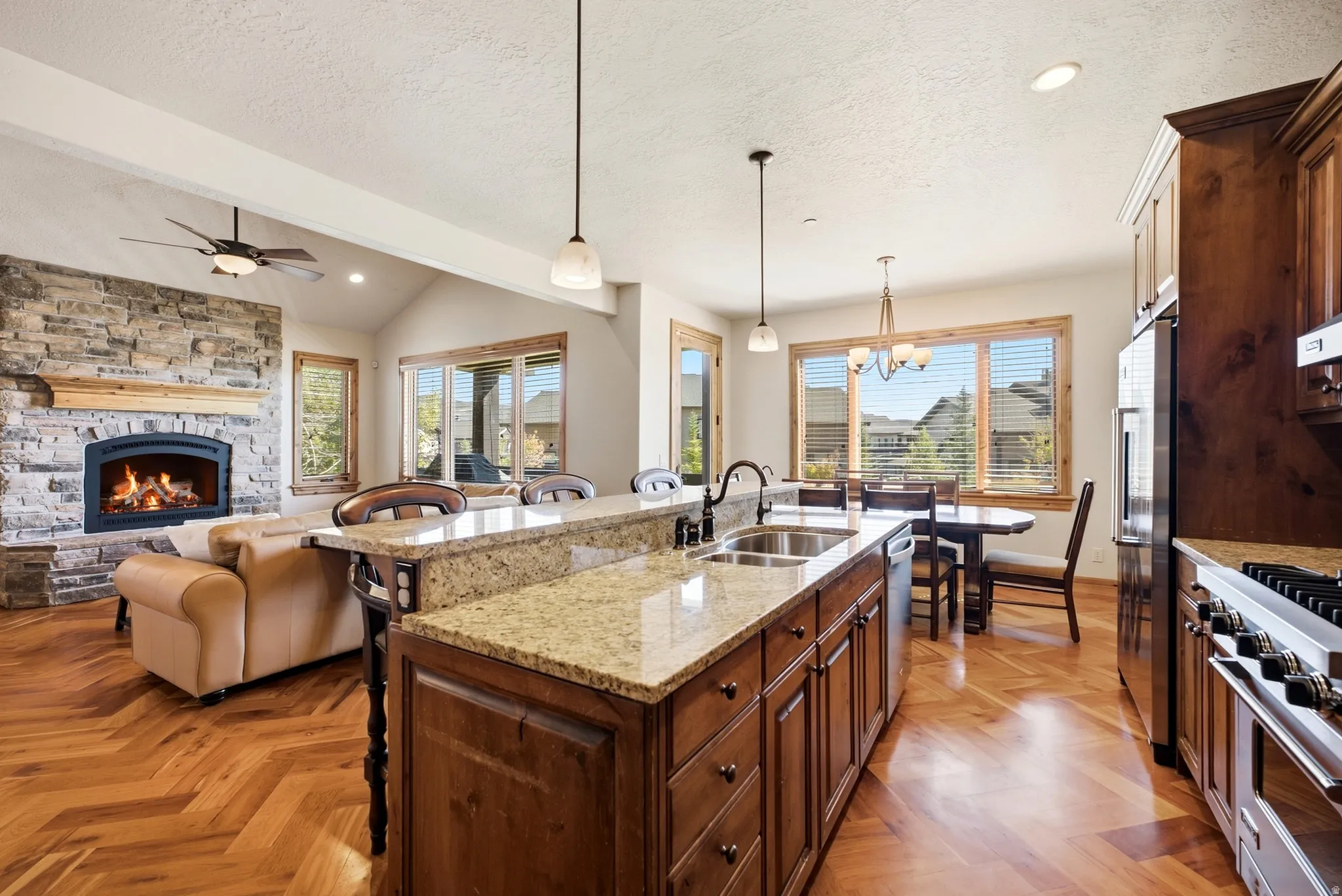 Kitchen featuring wood-finish flooring, granite countertops, wood cabinetry, and stainless steel appliances