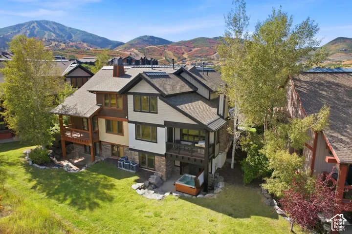 Multi-level exterior with balconies, stone accents, and a ground-level patio