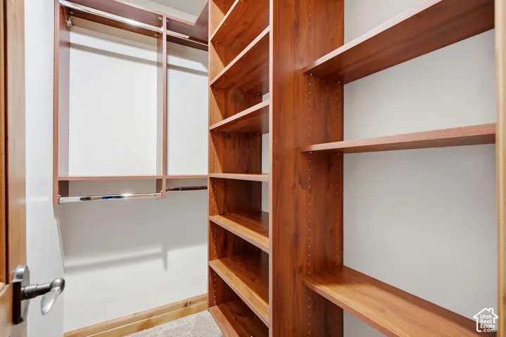 Custom closet system featuring wood-finish shelving and chrome hanging rods
