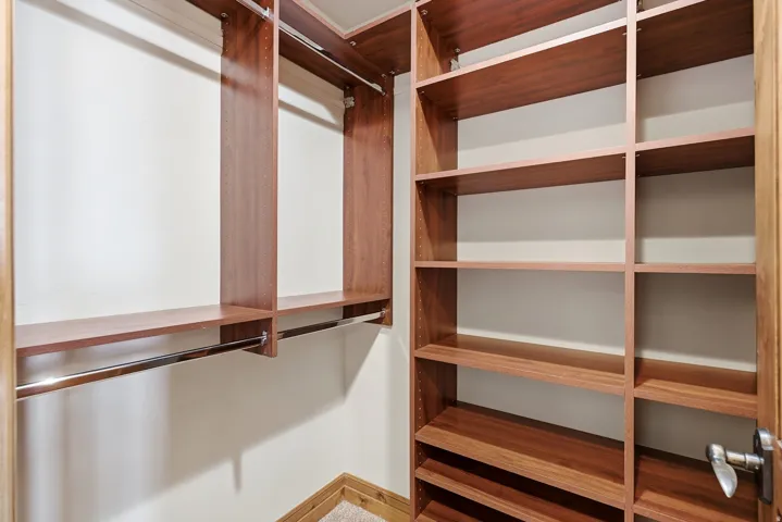 Integrated wood-finish shelving, multiple hanging rods, and built-in closet organization