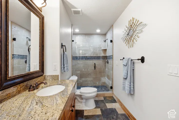 Vanity with stone countertop, undermount sink, and bronze-finish fixtures