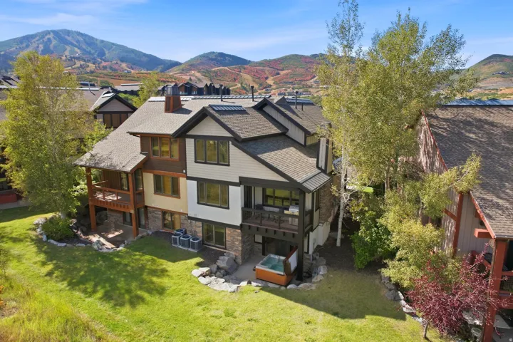 Multi-level exterior with balconies, stone accents, and a ground-level patio