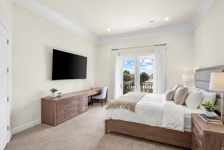 Crown molding throughout, recessed ceiling lighting, French doors with balcony access, and carpeted flooring