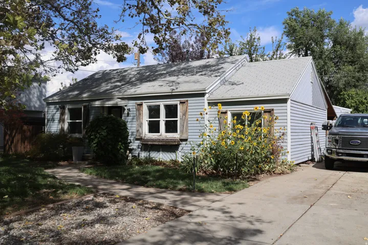 Light blue siding exterior with multiple windows and a concrete driveway