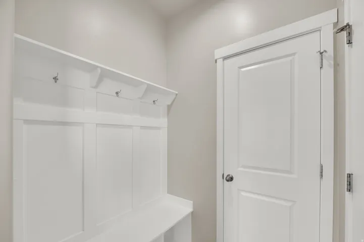 Built-in storage bench with coat hooks and overhead shelving