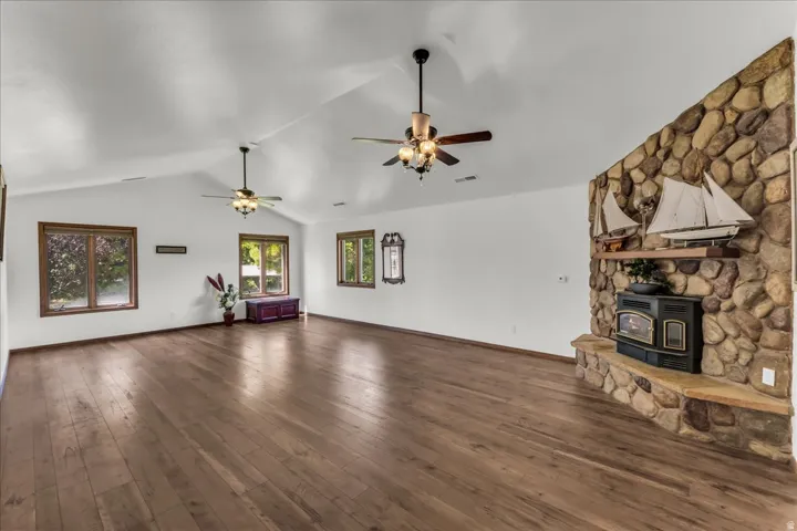 Spacious interior featuring a vaulted ceiling and wood-finish flooring